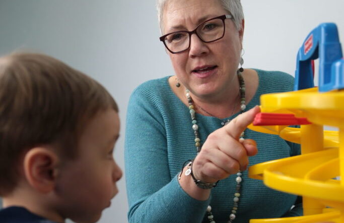 Teacher pointing and showing boy in classroom