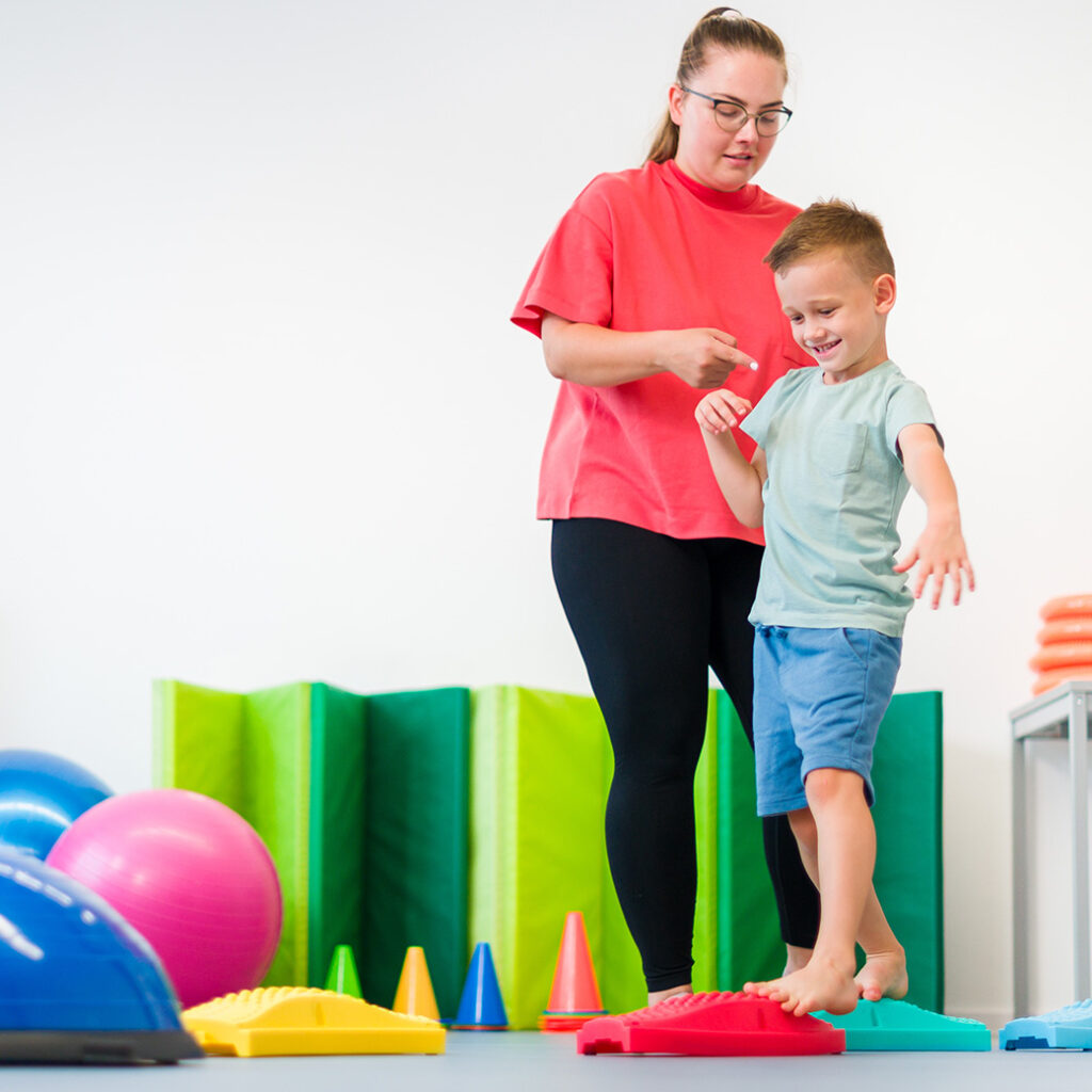 Physical Therapist working with young boy wearing shorts and tshirt
