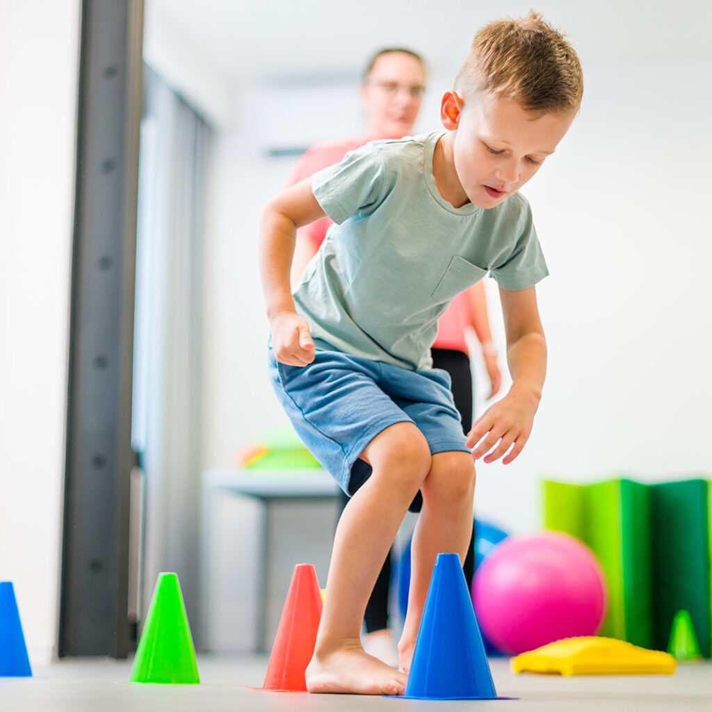 Physical Therapist working with young boy wearing shorts and tshirt
