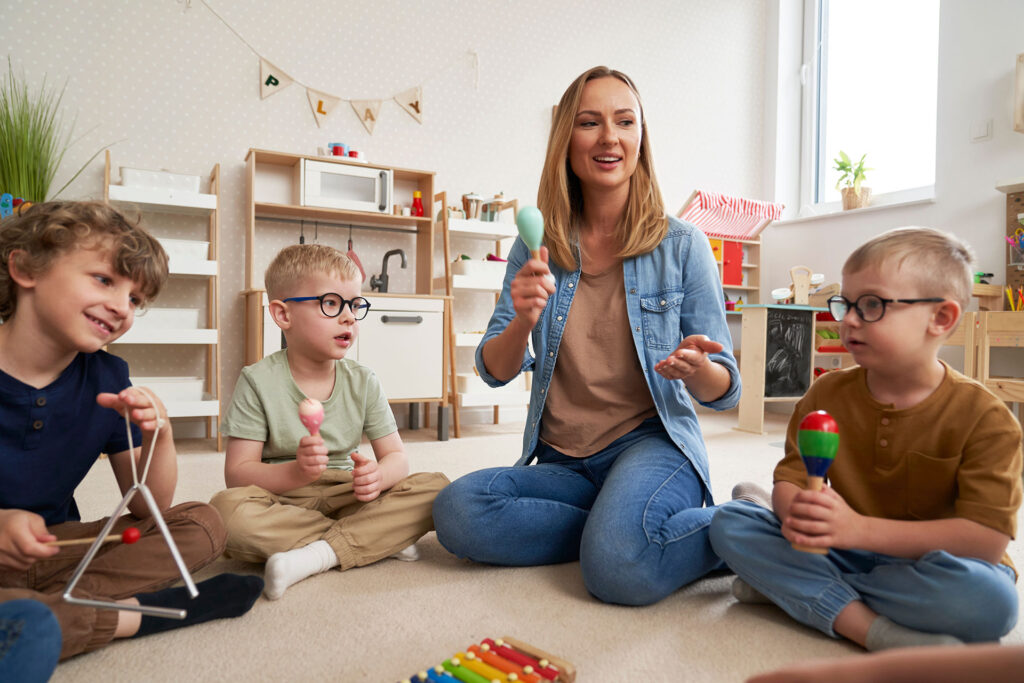Music teacher in classroom with students using maracas