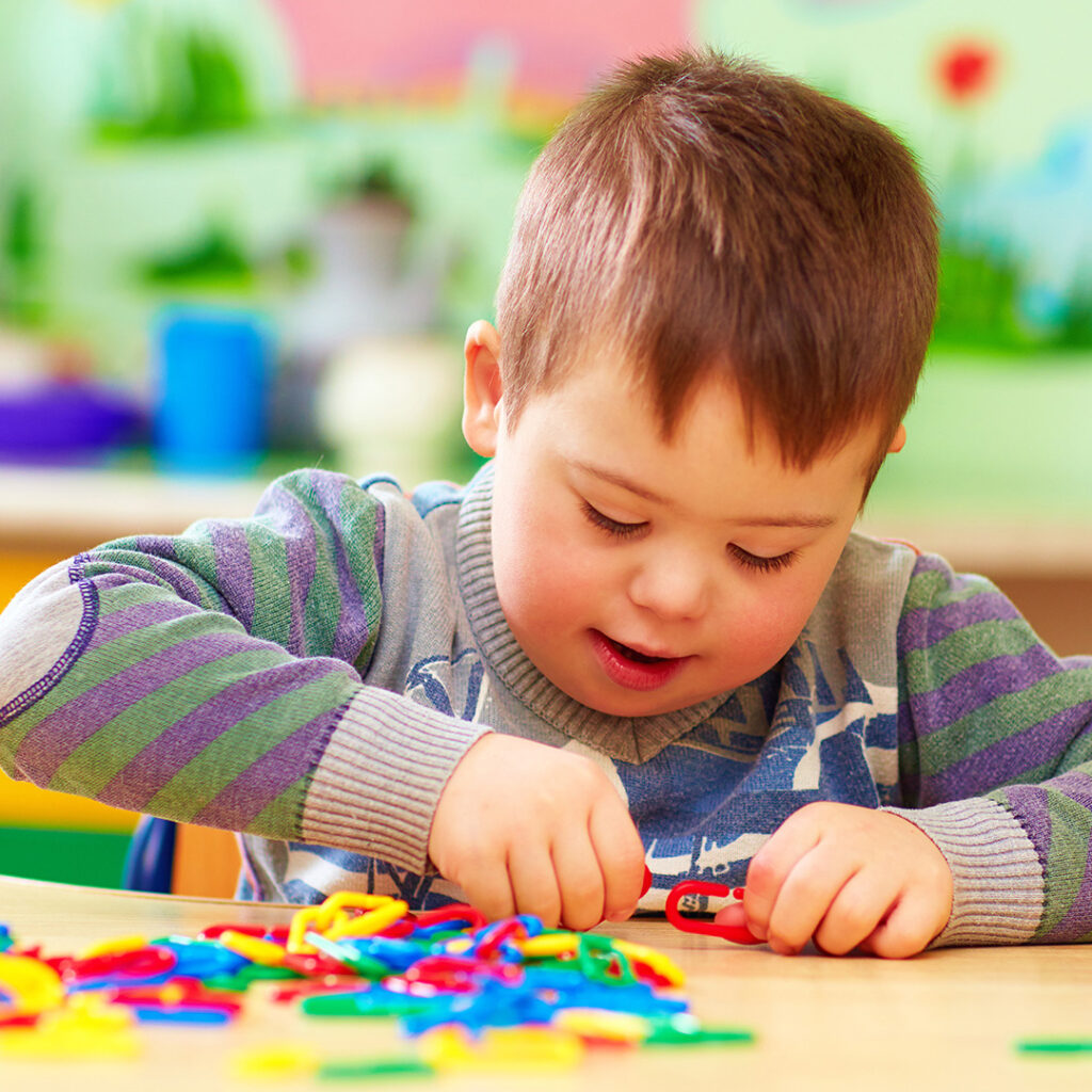 Autistic boy playing with toys in classroom